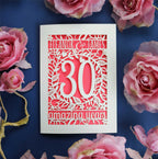 A cream and coral anniversary card. Card is laser cut and features floral details and text.