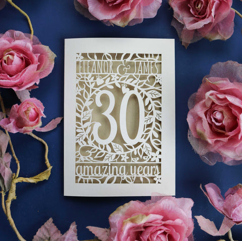 A laser cut anniversary card that has "Eleanor & James, 30 amazing years" surrounded by laser cut floral details and two tiny birds.  - A5 / Gold Leaf
