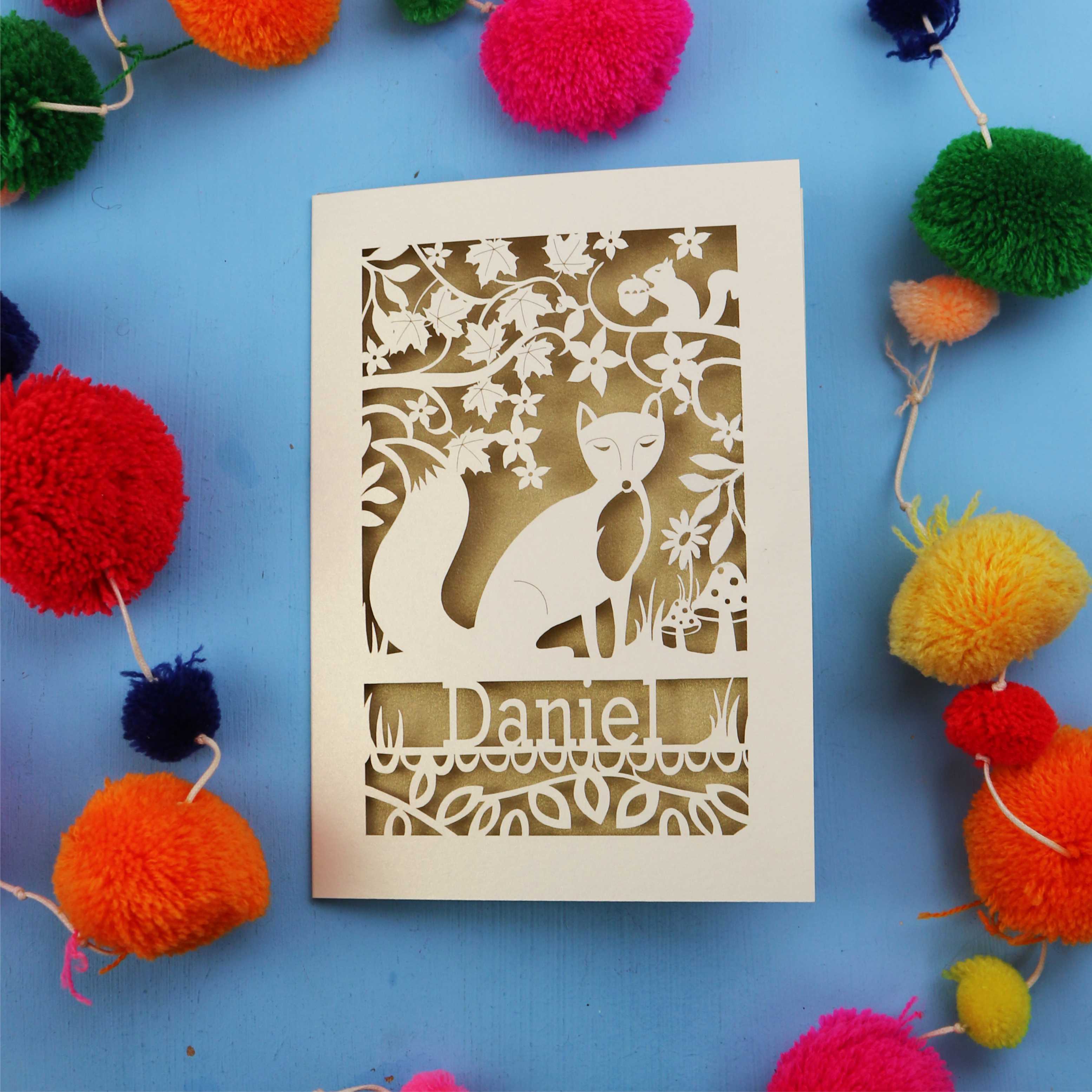 Decorative fox birthday card with fox design and colourful pom-poms on a blue background