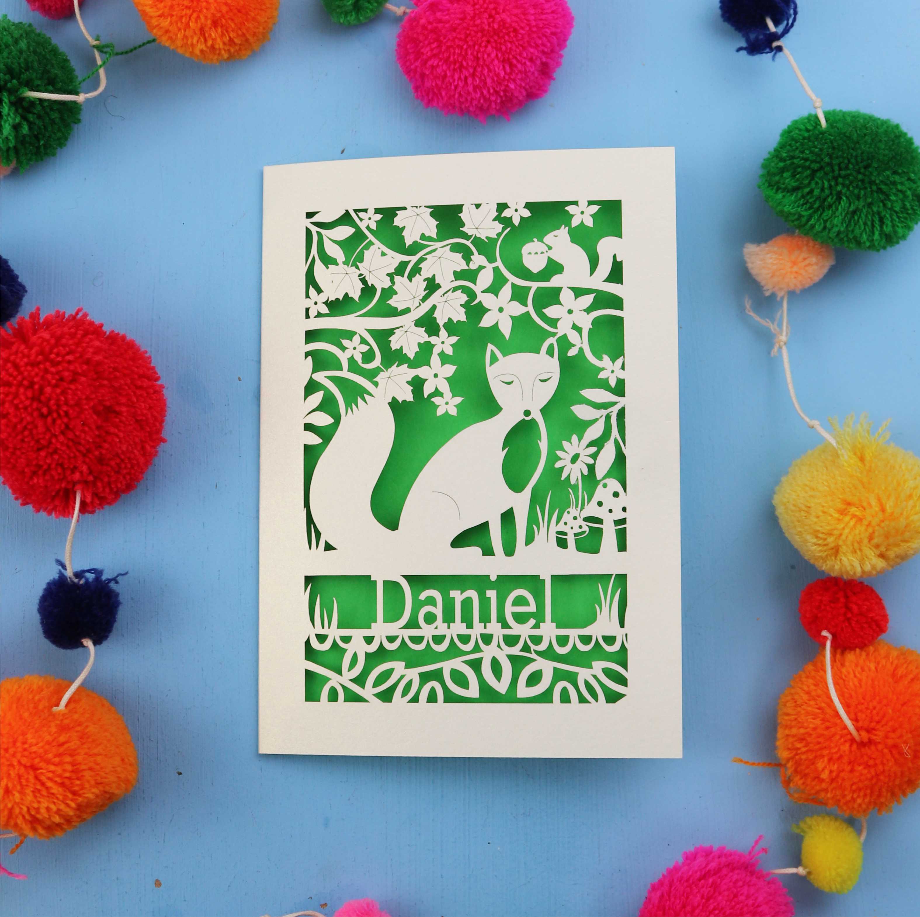 Decorative fox birthday card with fox design and colourful pom-poms on a blue background