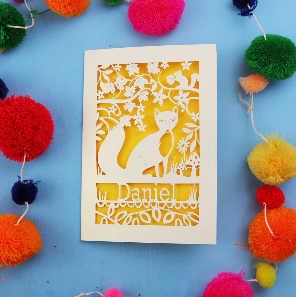 Decorative fox birthday card with fox design and colourful pom-poms on a blue background