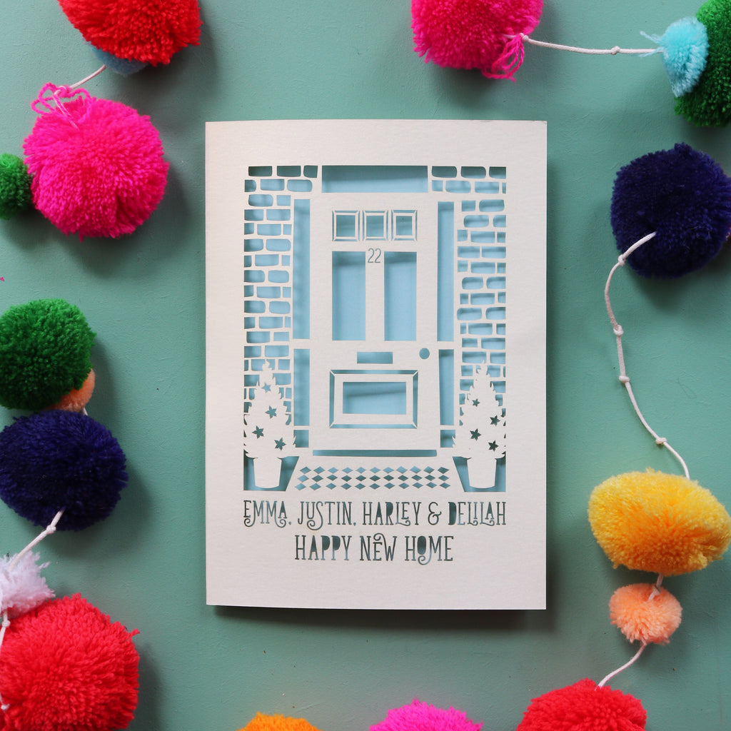 A personalised happy new home card with a cut out front door