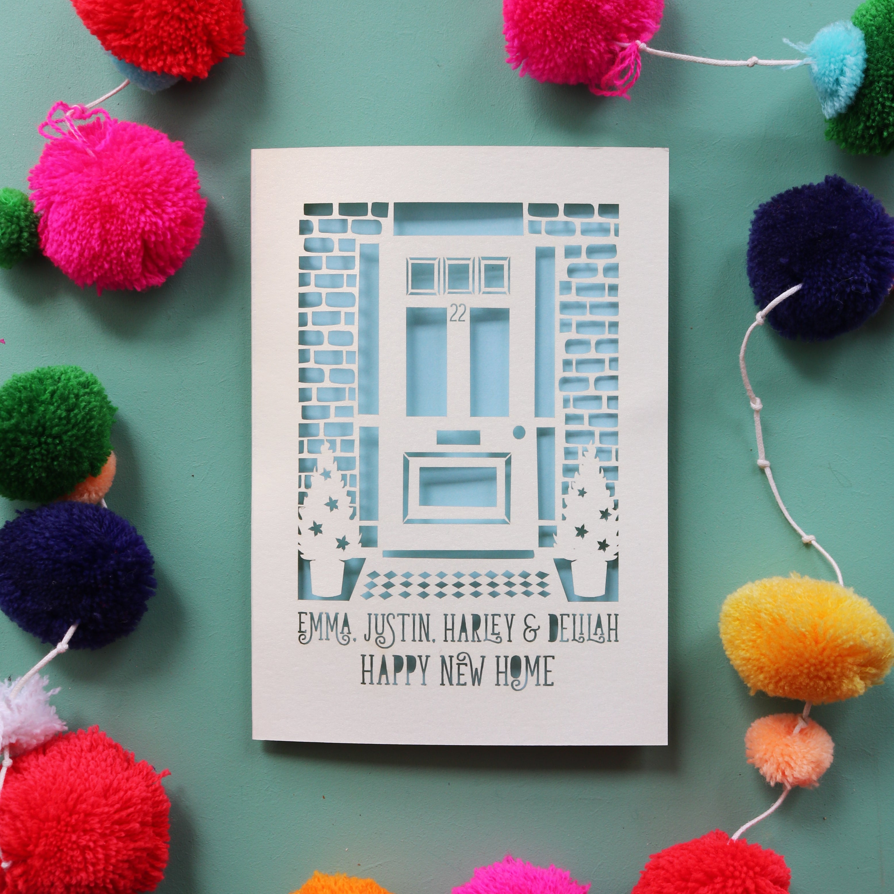 A personalised happy new home card with a cut out front door