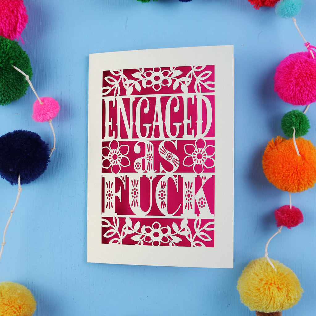 Card with 'ENGAGED AS F***' text on a blue background with colourful pom-poms.
