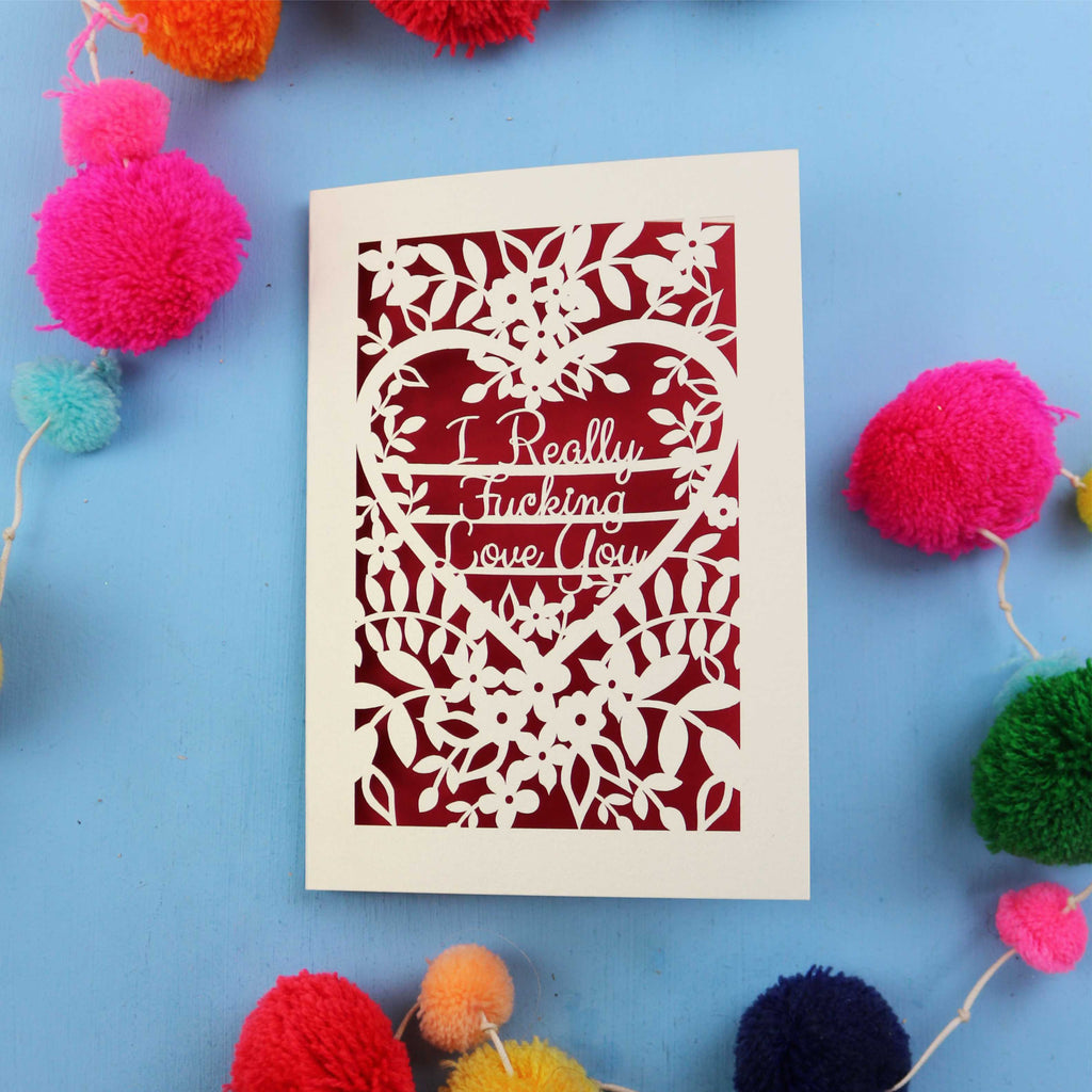 Funny Valentine's Card with floral design and text on a blue background with colourful pom-poms