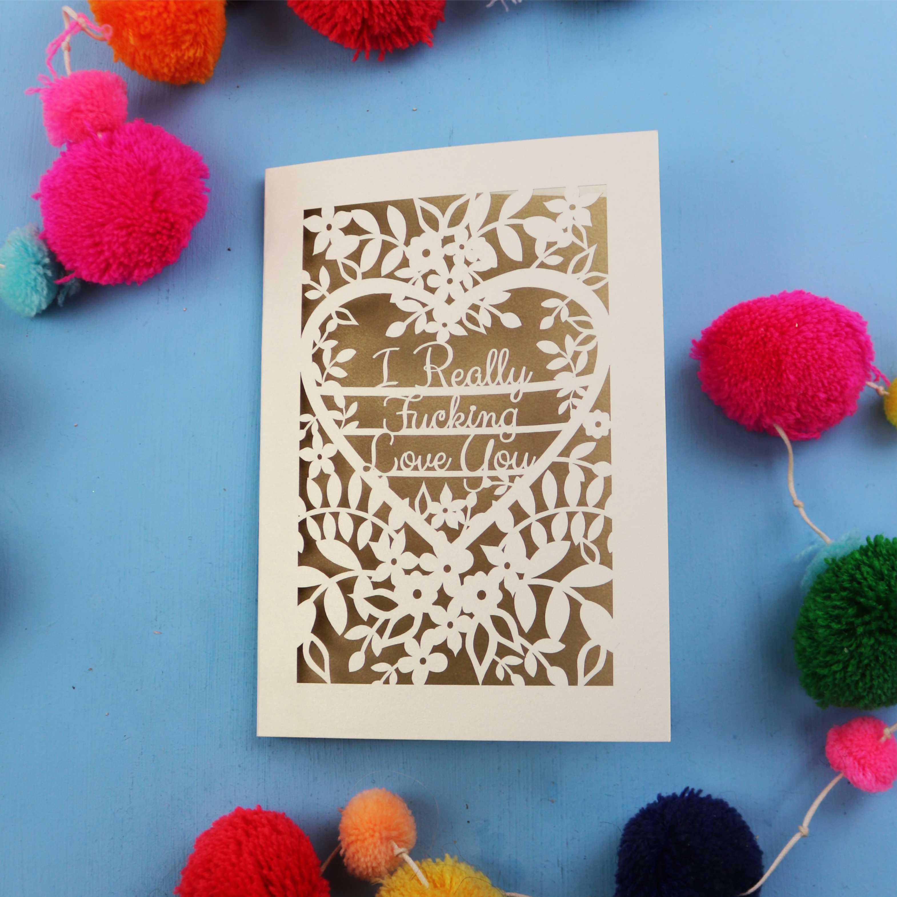 Funny Valentine's Card with floral design and text on a blue background with colourful pom-poms
