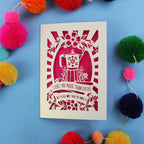 Funny Laser cut Valentine's card with coffee-themed design and the words "I love you more than coffee, but please don't make me prove it)" on a blue background with colourful pom-poms.