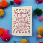 Christmas card with 'Merry Christmas to my girlfriend' text on a blue background with colourful pom-poms.