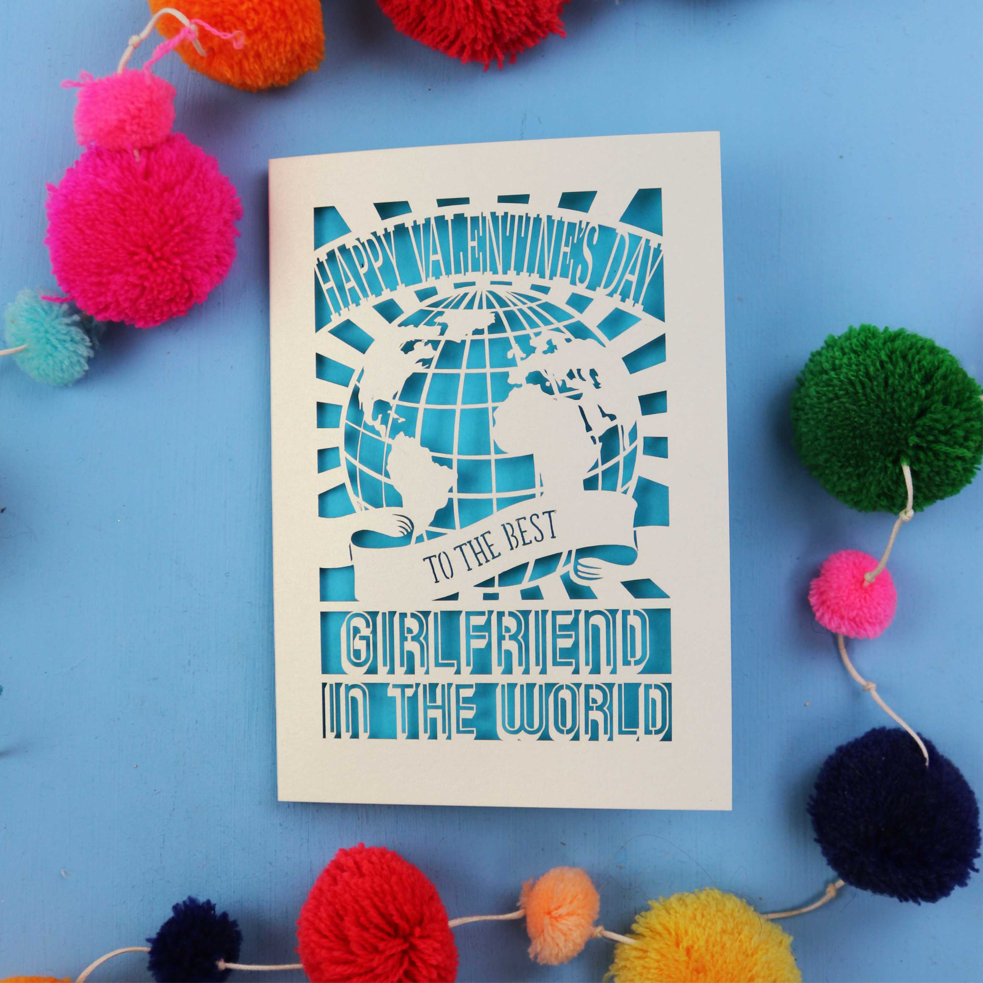 A cut out girlfriend Valentine's card that features a paper cut out World design and the words "Happy Valentine's Day to the Best Girlfriend in the World"