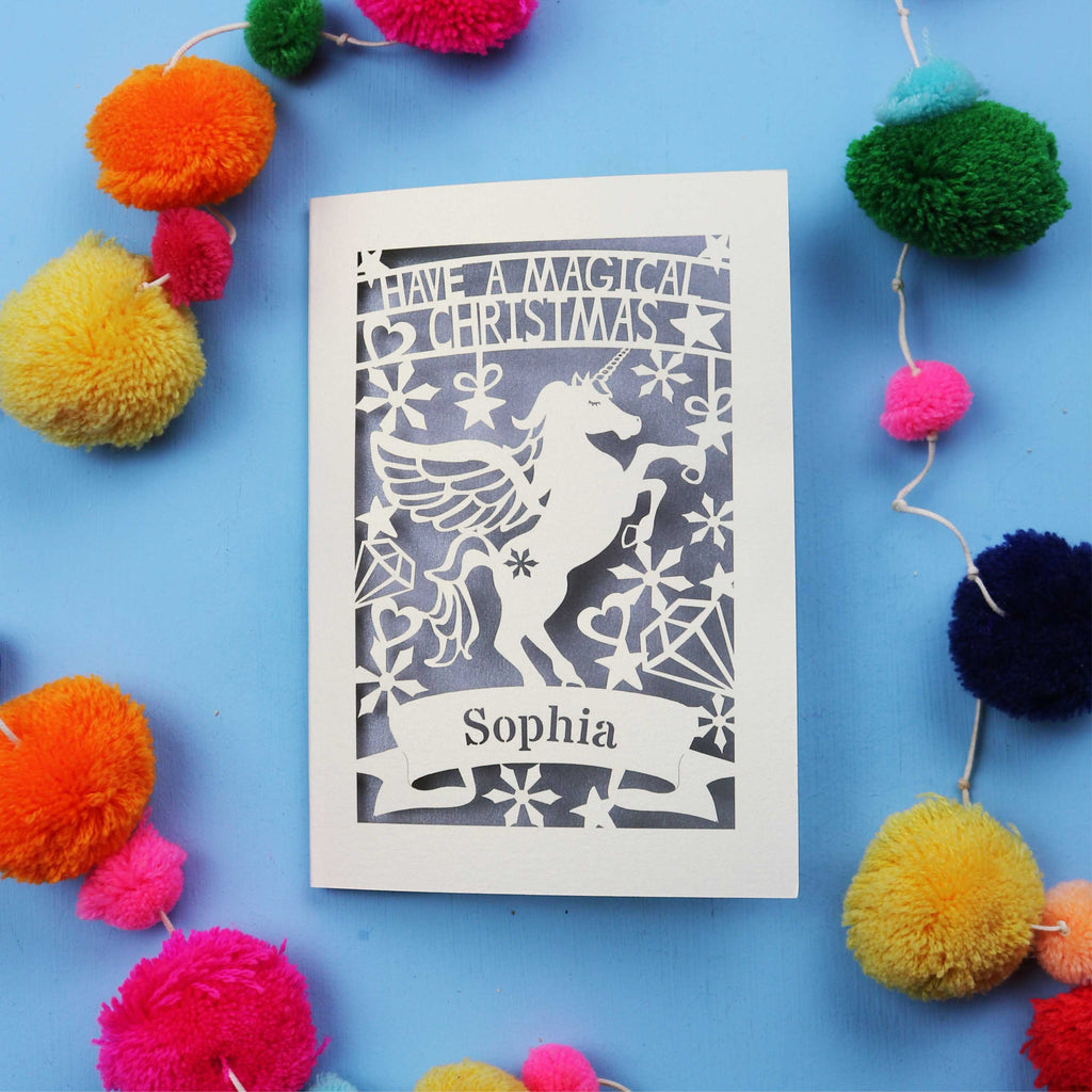 A personalised laser cut girls' Christmas card with a unicorn and the words "Have a magical Christmas, Name"
