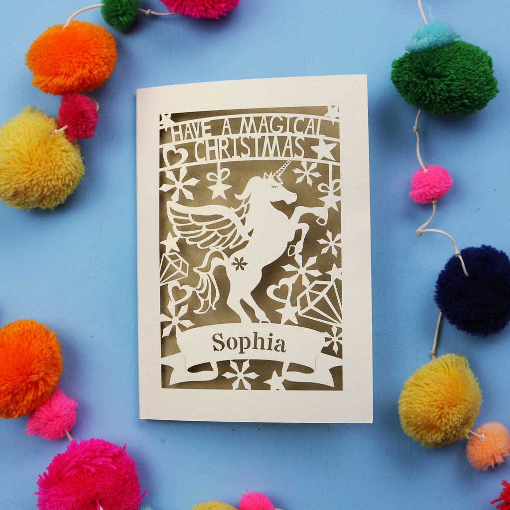 A personalised laser cut girls' Christmas card with a unicorn and the words "Have a magical Christmas, Name"