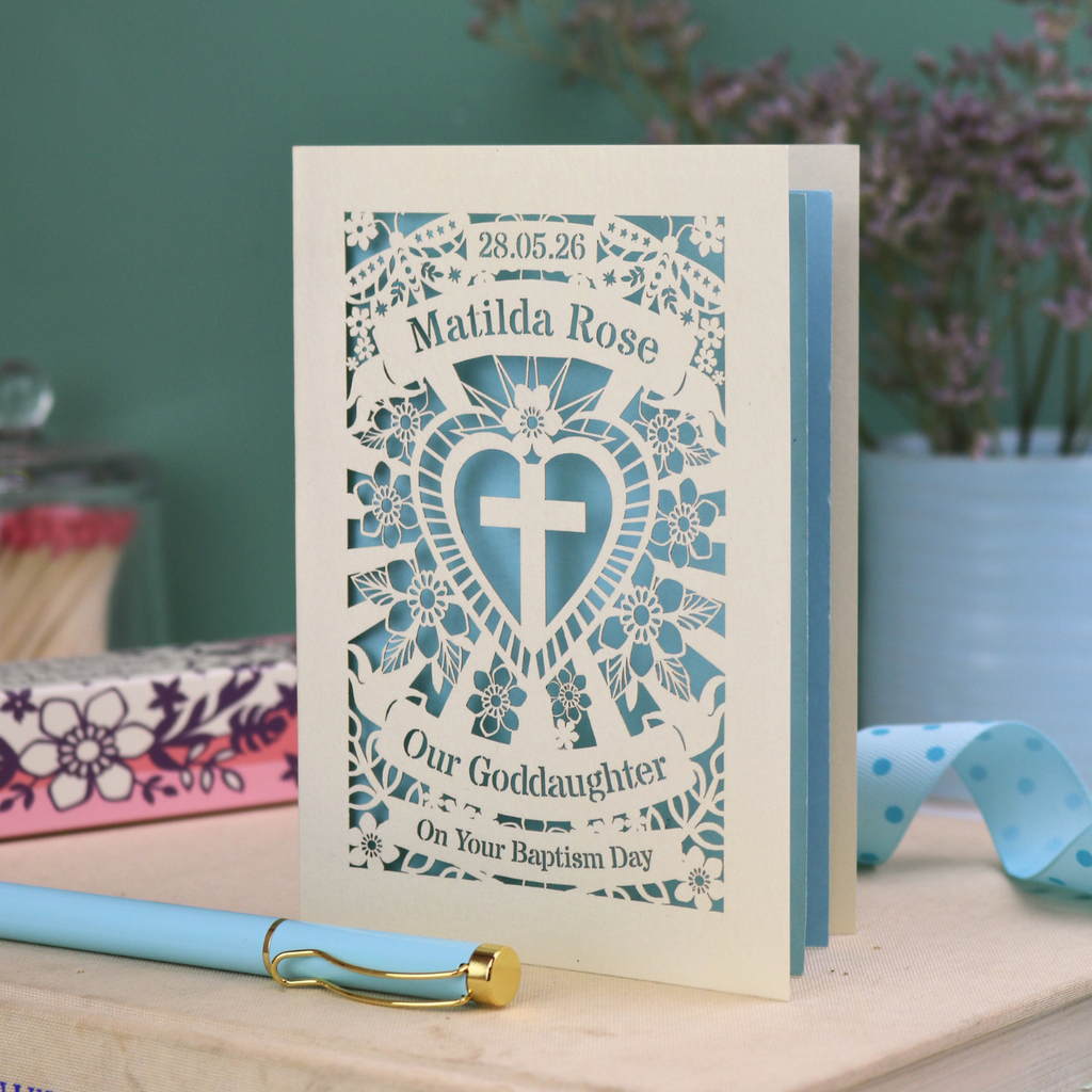 Personalised laser cut Baptism day card from Godparents with decorative design and text on a wooden surface.