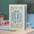 Personalised laser cut Baptism day card from Godparents with decorative design and text on a wooden surface.