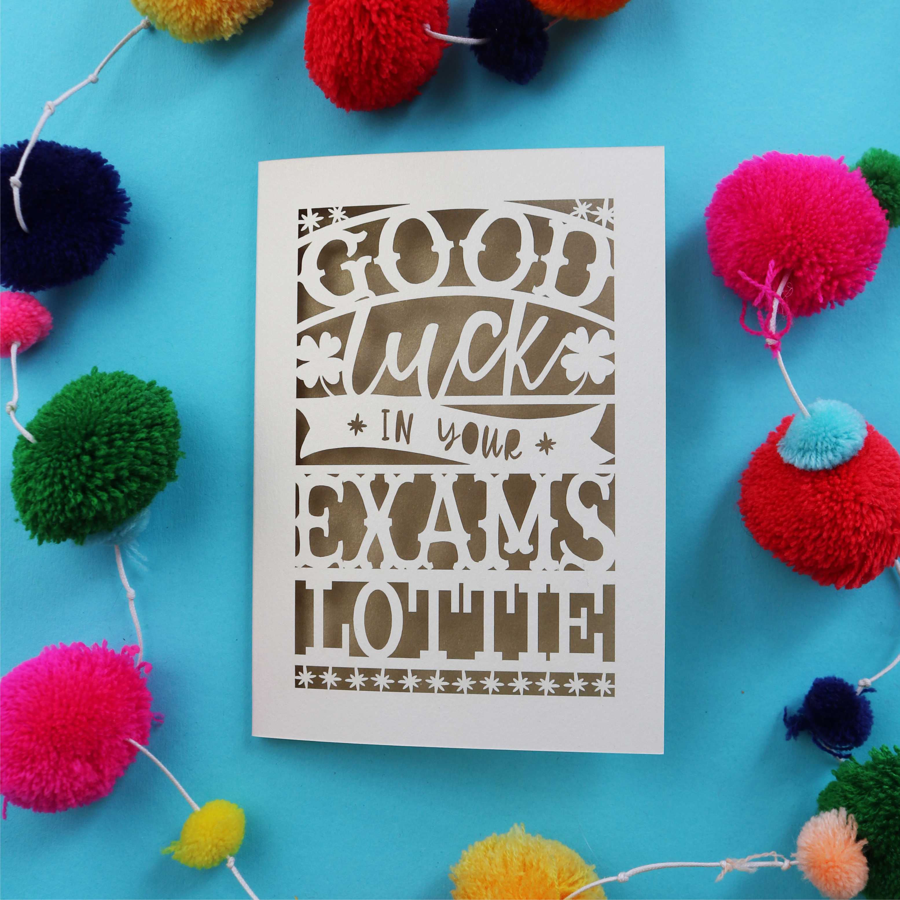 A paper cut card that says "Good luck in your exams" and is personalised with a name