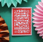 A red A6 Christmas card with  'Have a very merry Christmas Gran & Grandad' text, placed on a green background