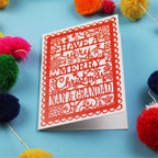 Grandparents Christmas card with decorative text on a blue background with colourful pom-poms.