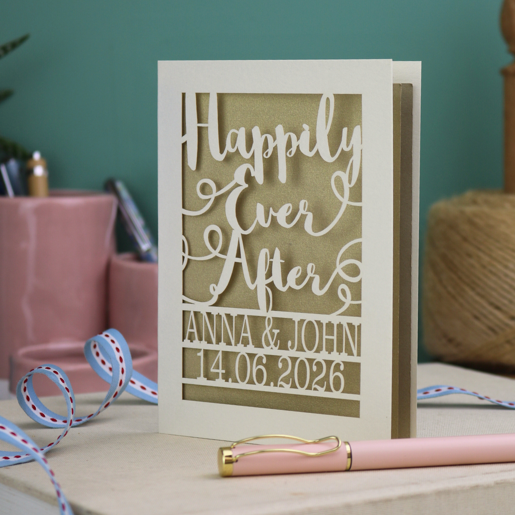 A laser cut wedding card with cut out text, 'Happily Ever After' in a script font, personalised with 'Anna & John, 14.06.2026'