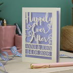 A laser cut wedding card with cut out text, 'Happily Ever After' in a script font, personalised with 'Anna & John, 14.06.2026'