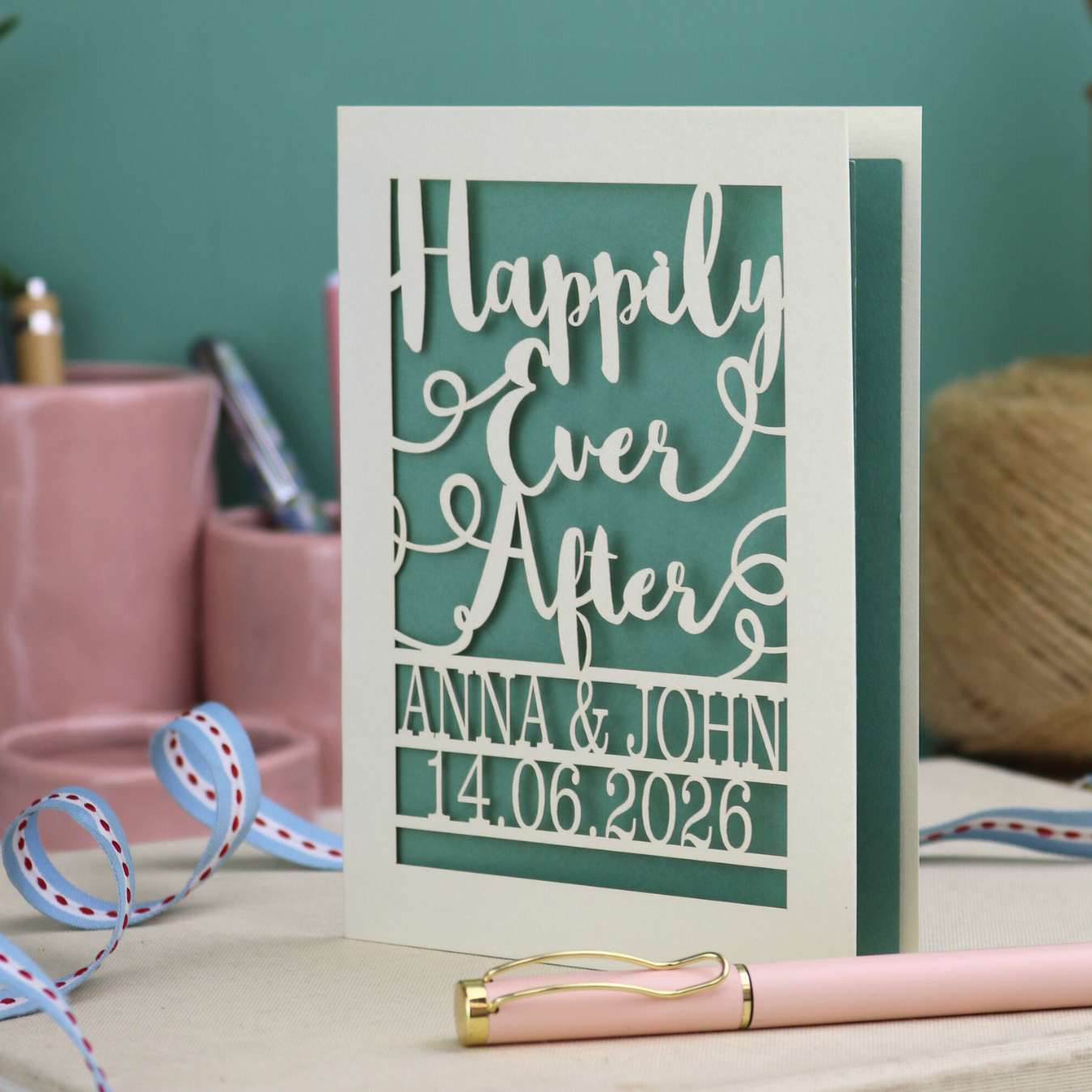 A laser cut wedding card with cut out text, 'Happily Ever After' in a script font, personalised with 'Anna & John, 14.06.2026'