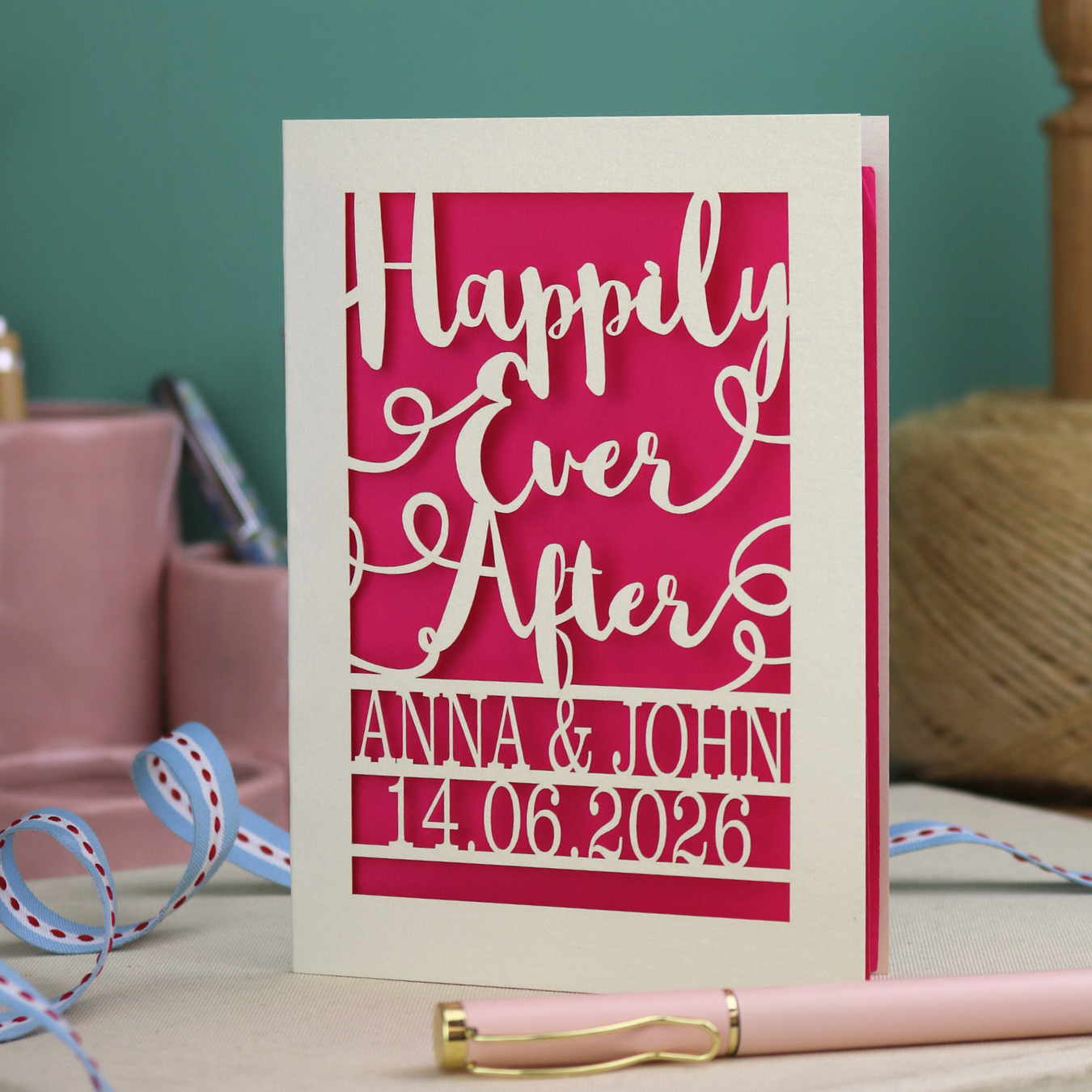 A laser cut wedding card with cut out text, 'Happily Ever After' in a script font, personalised with 'Anna & John, 14.06.2026'