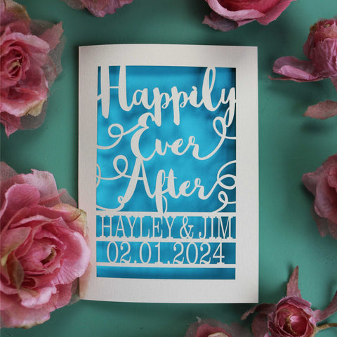 A personalised laser cut wedding card with "Happily Ever After" in a calligraphy font with names and date underneath.