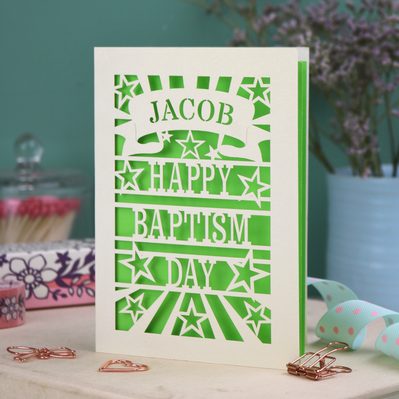 Personalised Baptism Card with 'Happy Baptism Day' text and stars on a decorative background, personalised with a stencil-font cut out name in a banner at the top