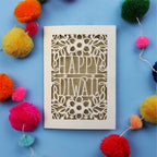 Laser Cut Diwali Card with 'Happy Diwali' design surrounded by colourful pom-poms on a blue background