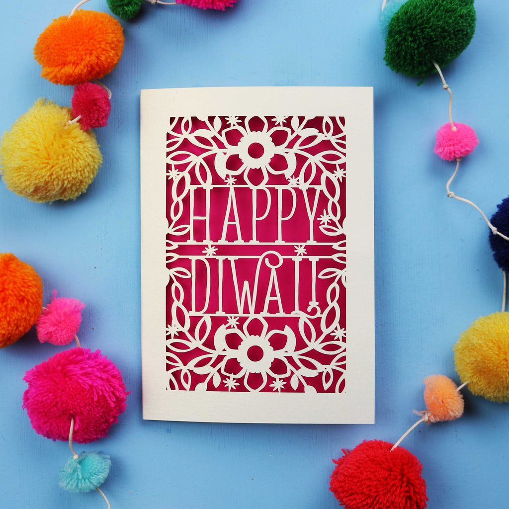 Laser Cut Diwali Card with 'Happy Diwali' design surrounded by colourful pom-poms on a blue background