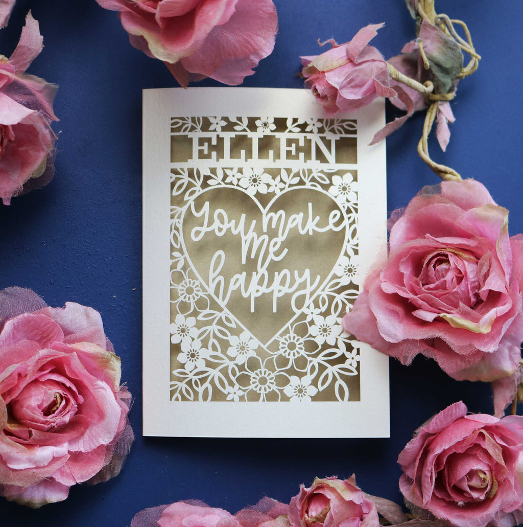 A personalised laser cut Valentines Card that says "Name, You make me happy."