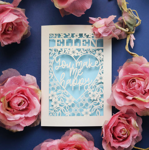 A personalised laser cut Valentine's Card that says "Name, You make me happy." - A5 / Light Blue