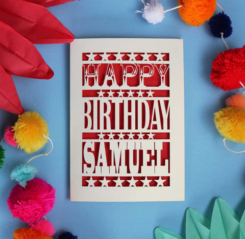 A laser cut Happy Birthday card, personalised with a name. Card is cream with a red paper backing.