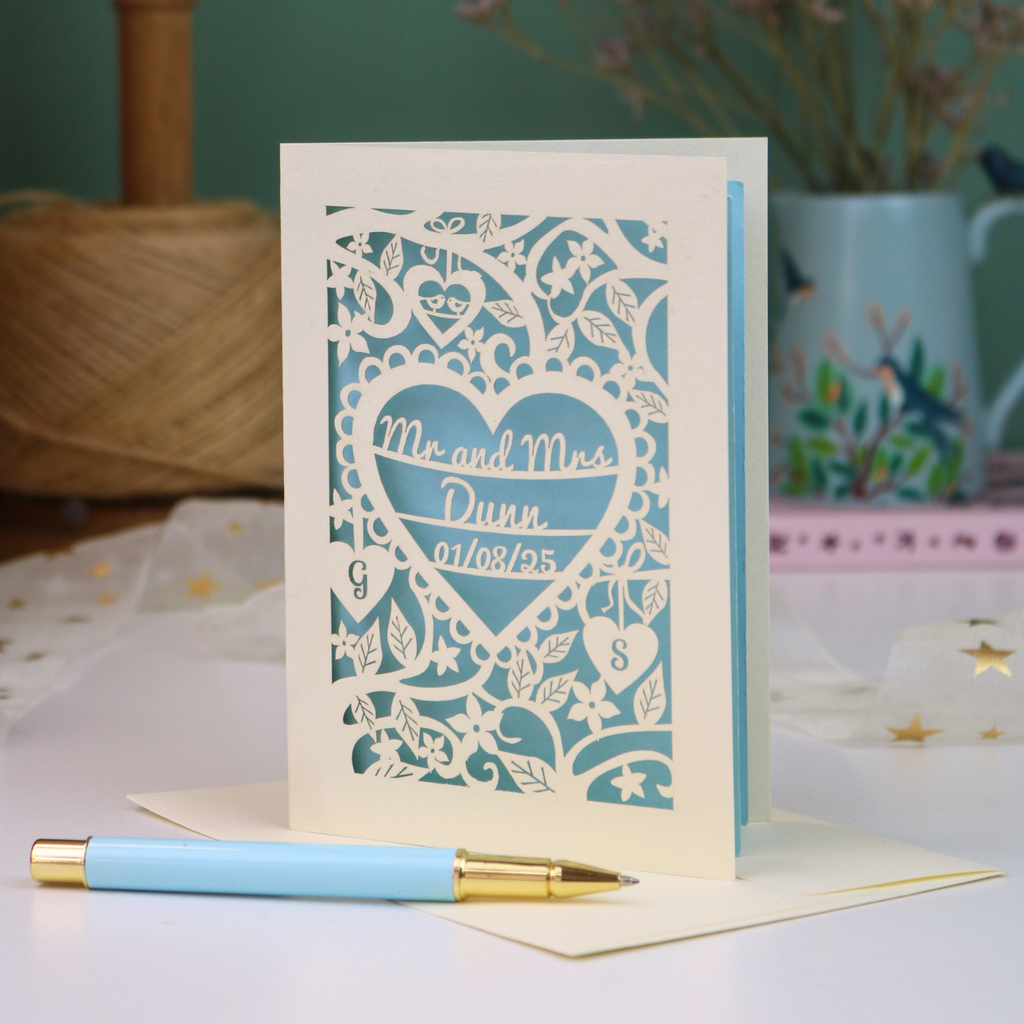 A personalized laser-cut wedding anniversary card with a heart-shaped cut out in the centre reading 'Mr. and Mrs. Dunn, 01/08/25