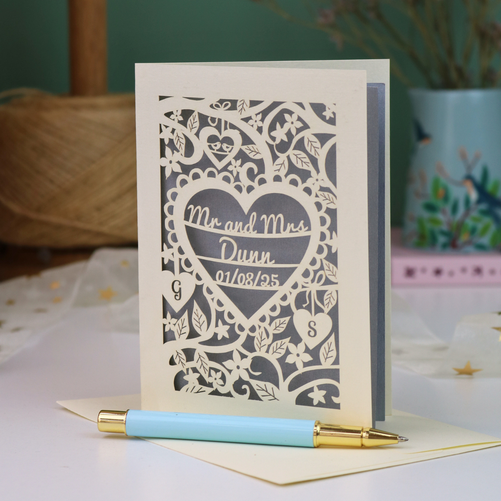 A personalized laser-cut wedding anniversary card with a heart-shaped cut out in the centre reading 'Mr. and Mrs. Dunn, 01/08/25