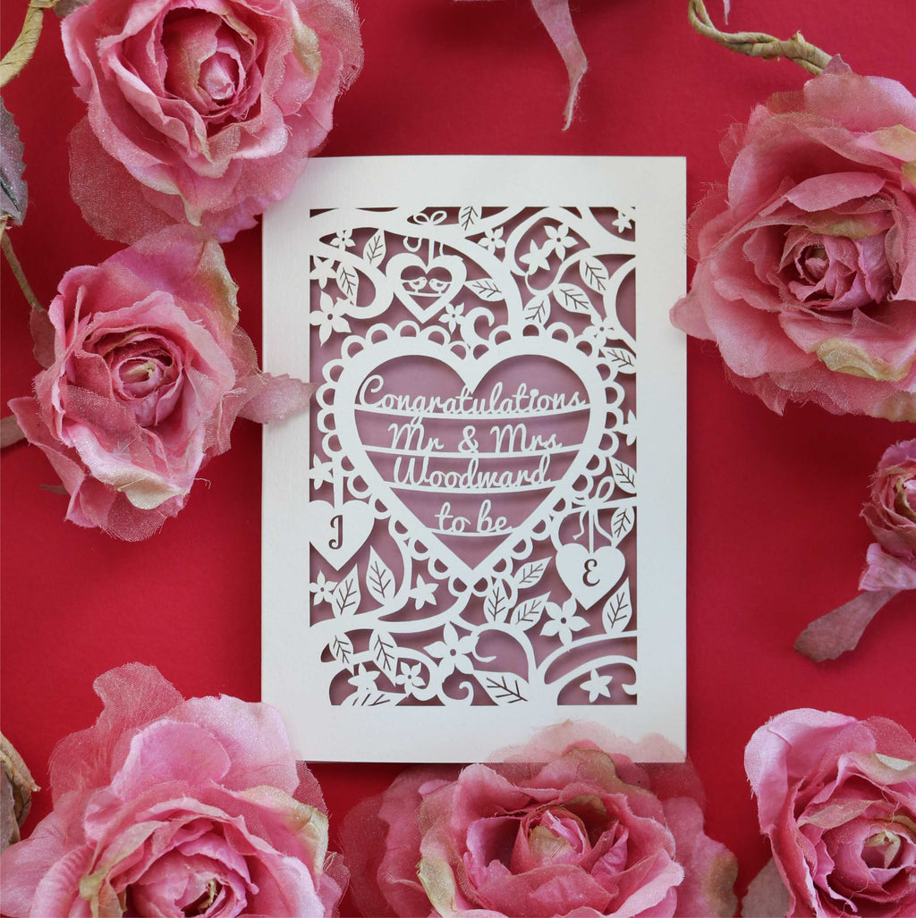 A personalised paper cut engagement card with words inside a laser cut heart