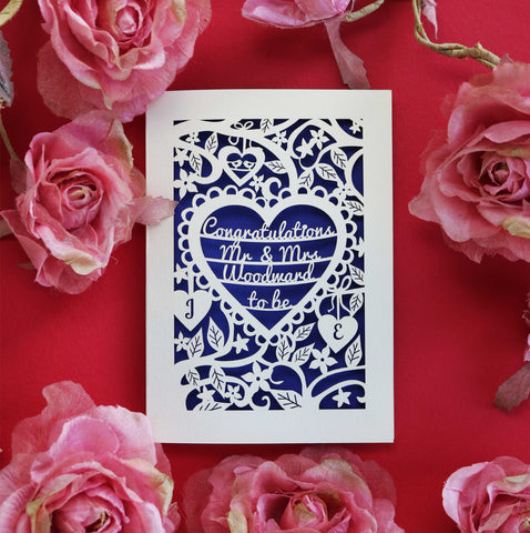 A laser cut card with text inside a heart, surrounded by flowers and leaves.  - A5 / Infra Violet