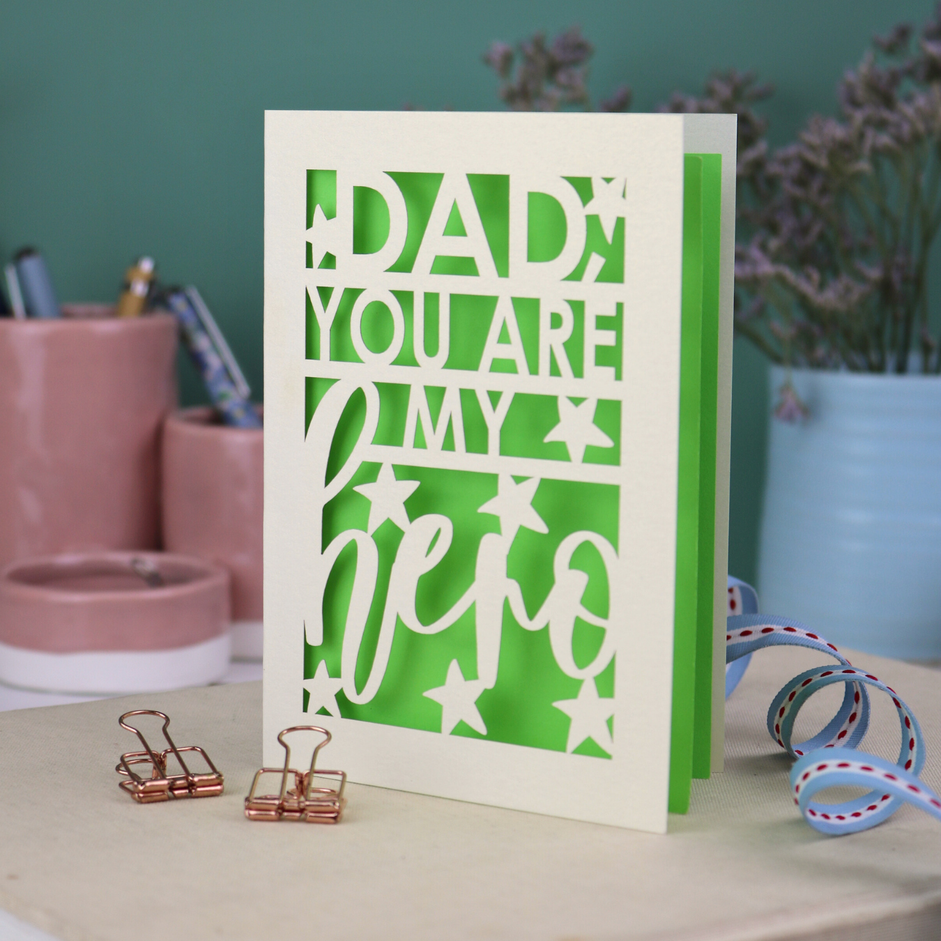 A laser cut Father's Day card with the text, "Dad, you are my hero"