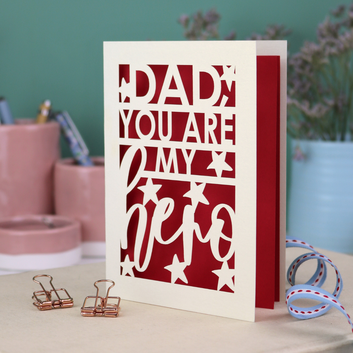 A laser cut Father's Day card with the text, "Dad, you are my hero"