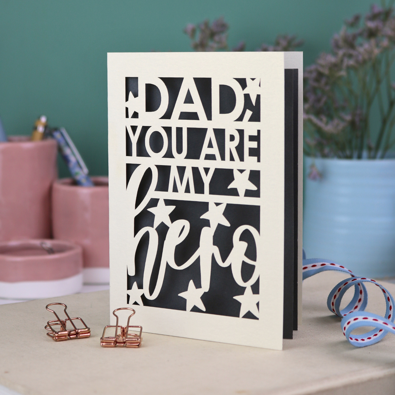 A laser cut Father's Day card with the text, "Dad, you are my hero"