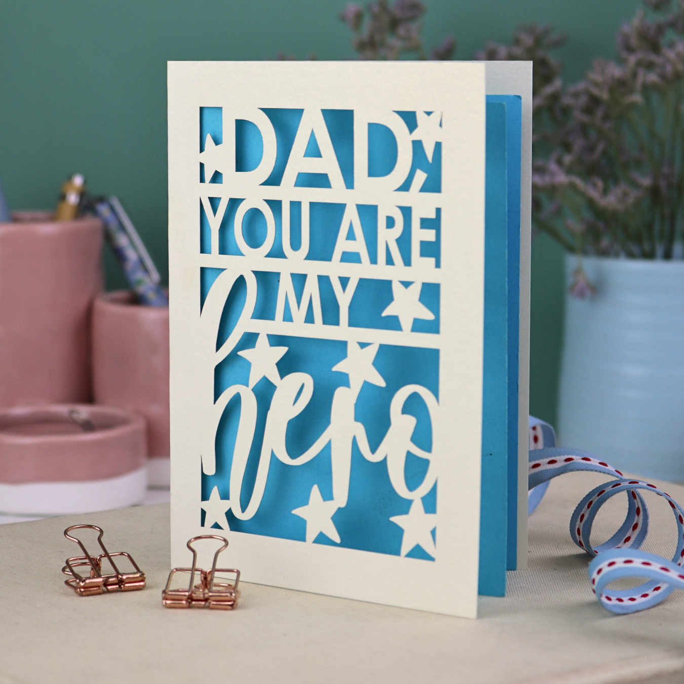 A laser cut Father's Day card with the text, "Dad, you are my hero"