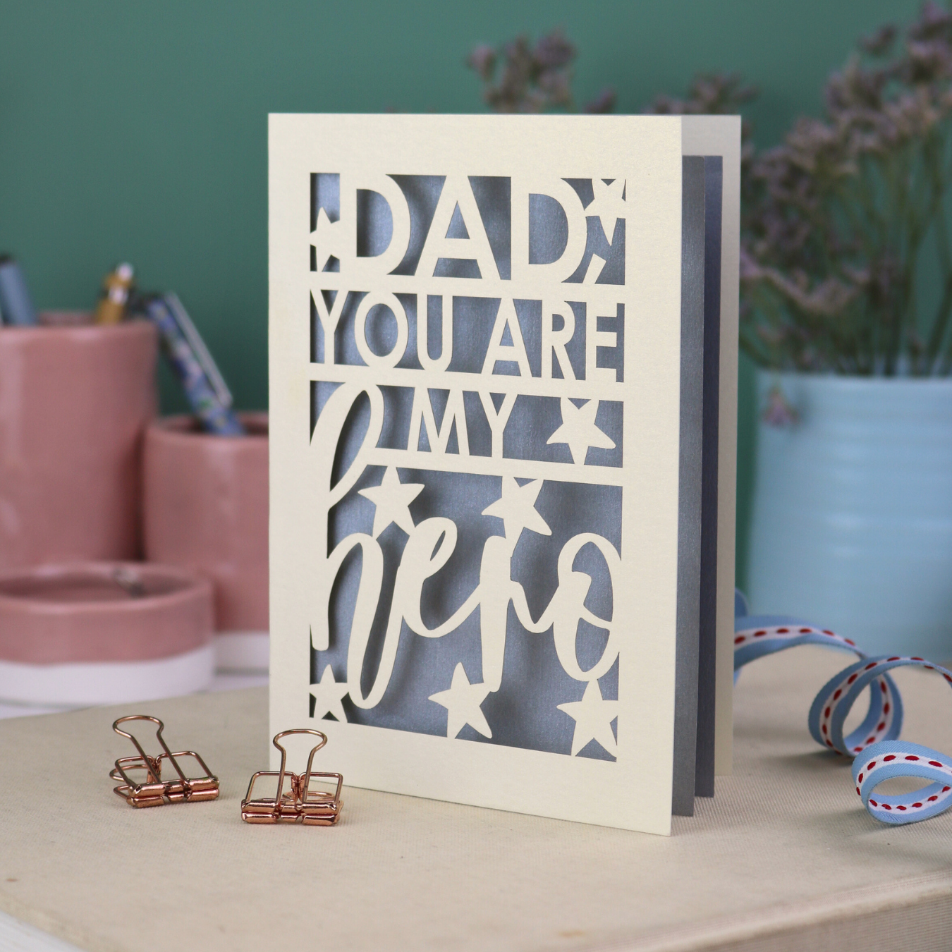 A laser cut Father's Day card with the text, "Dad, you are my hero"