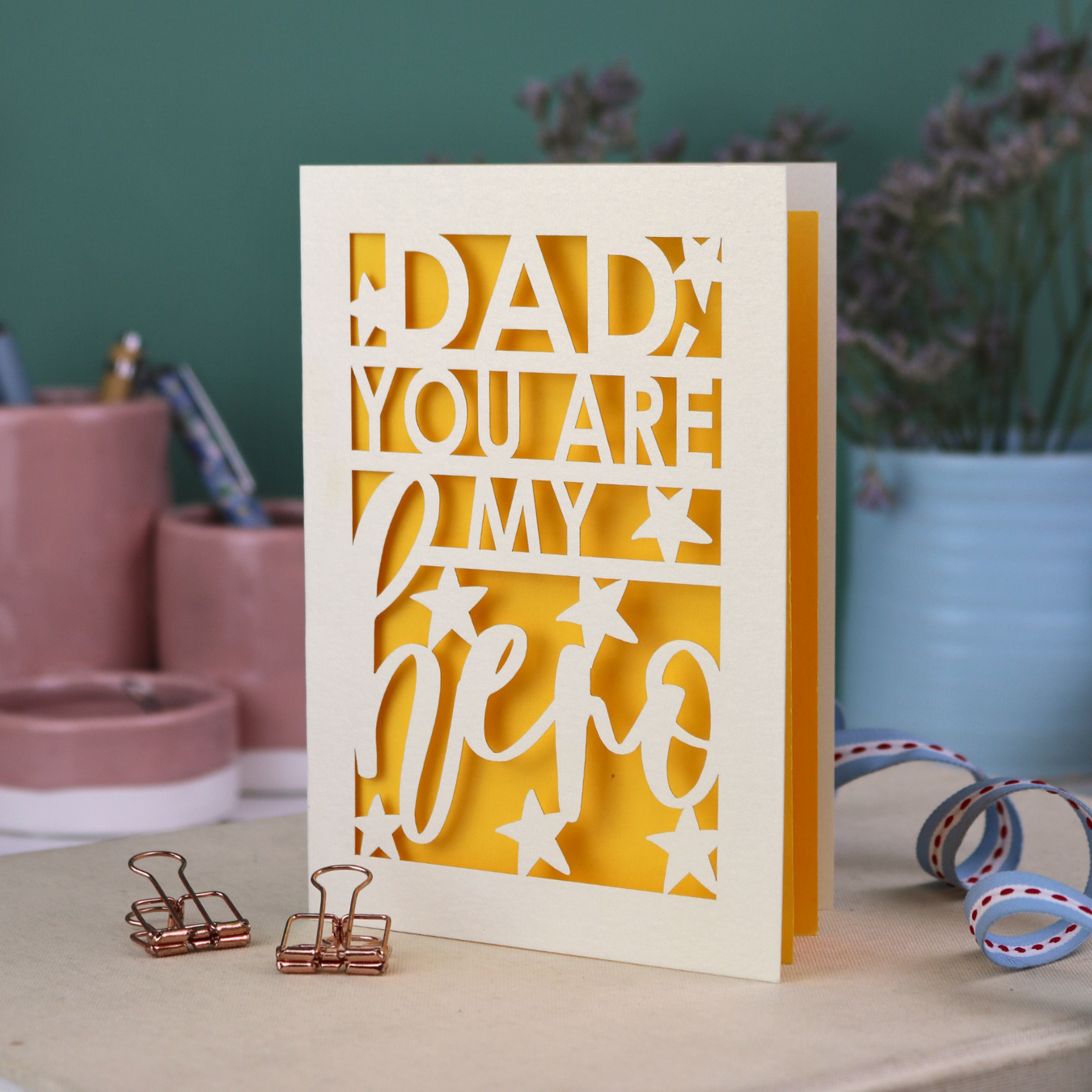 A laser cut Father's Day card with the text, "Dad, you are my hero"