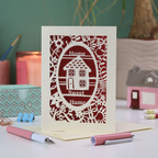 A laser cut new home card with floral border, house design and the words "Home sweet home"