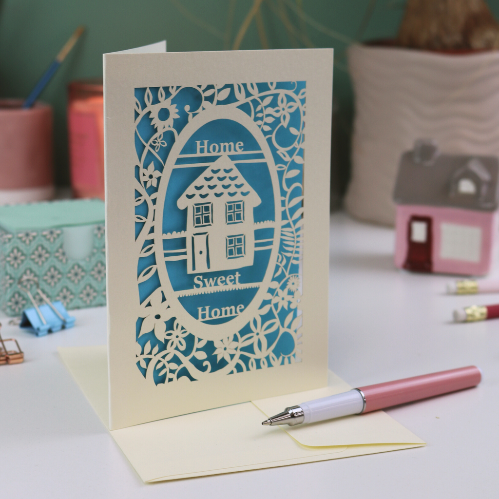A laser cut new home card with floral border, house design and the words "Home sweet home"