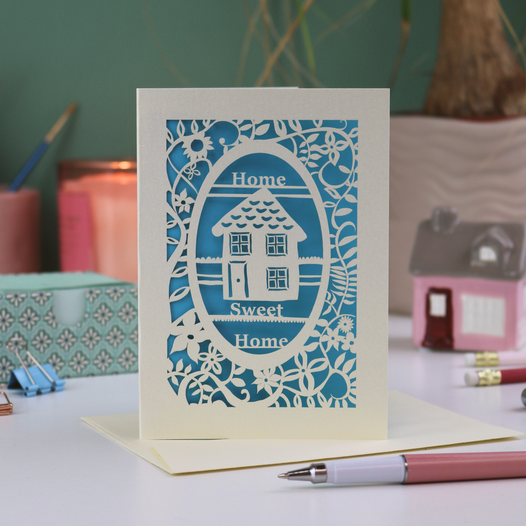 A laser cut new home card with floral border, house design and the words "Home sweet home"