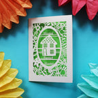 A unique home card that has a laser cut house and the words "Home sweet home"