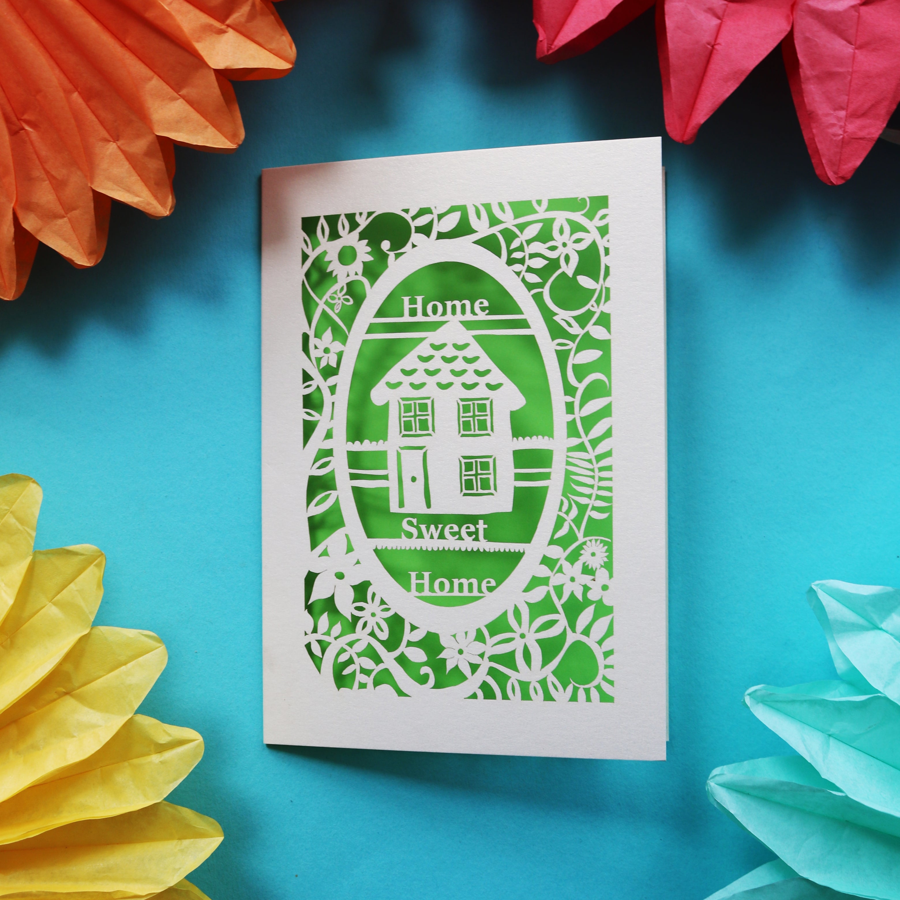 A unique home card that has a laser cut house and the words "Home sweet home"