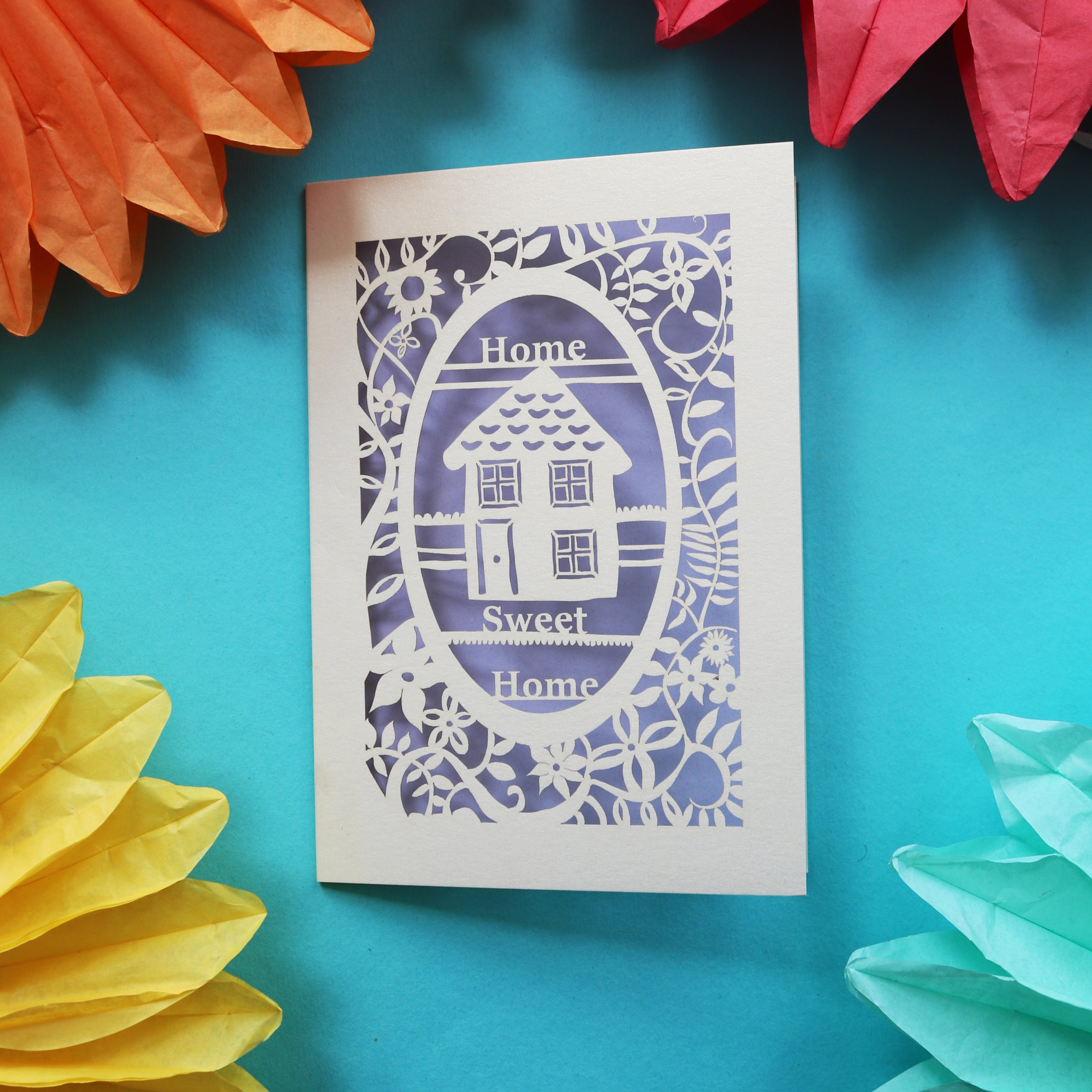 A unique housewarming card that has a laser cut house and the words "Home sweet home"