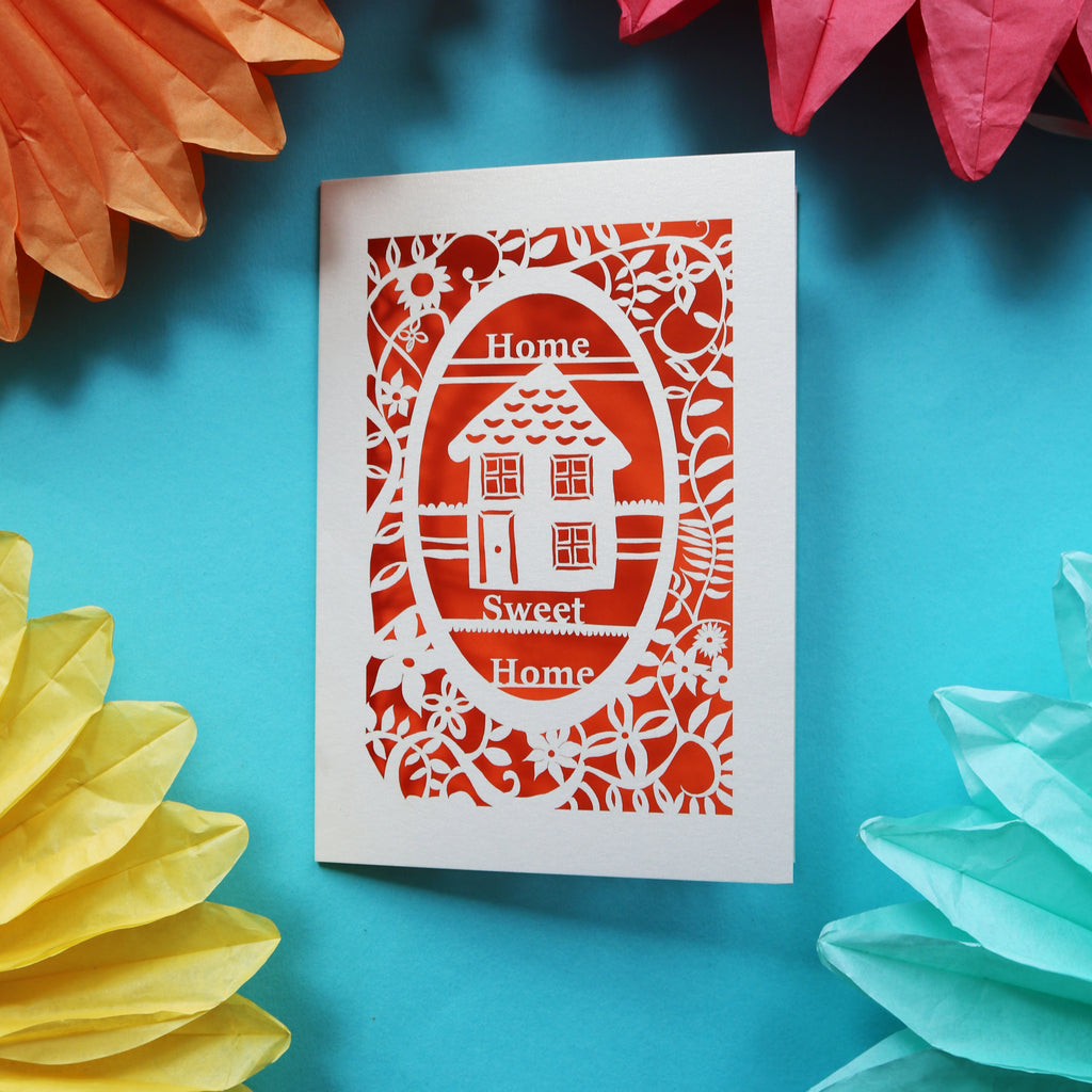 A home buyers card that has a laser cut house and the words "Home sweet home"
