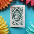 A house card that has a laser cut house and the words "Home sweet home"