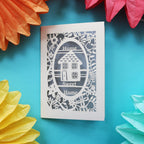 A cut out new home card that has a laser cut house and the words "Home sweet home"